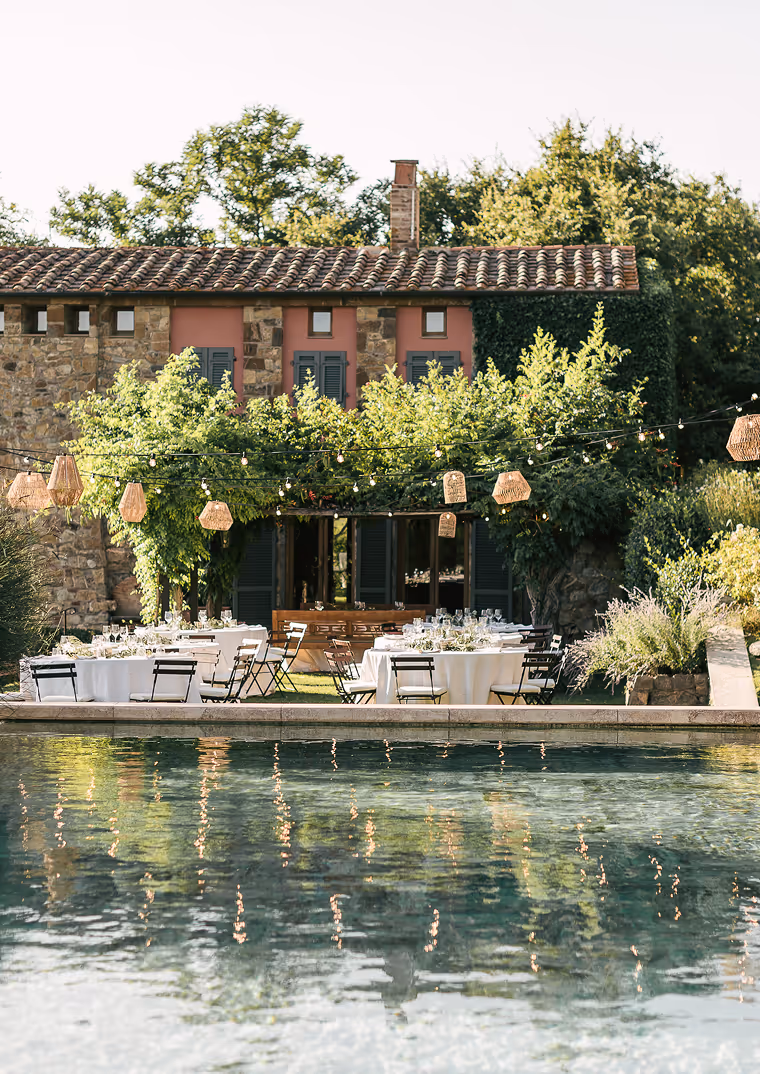 Elegante allestimento per pre wedding all'aperto al Castello di Vicarello, con tavoli tondi apparecchiati a bordo piscina, lanterne sospese.